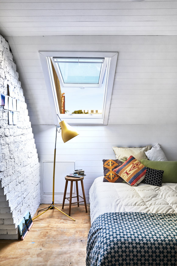The attic space was created to make a fifth bedroom in the house. A skylight was added, opening up to the neighbourhood skyline, and the brick walls painted white to create a light and airy space.