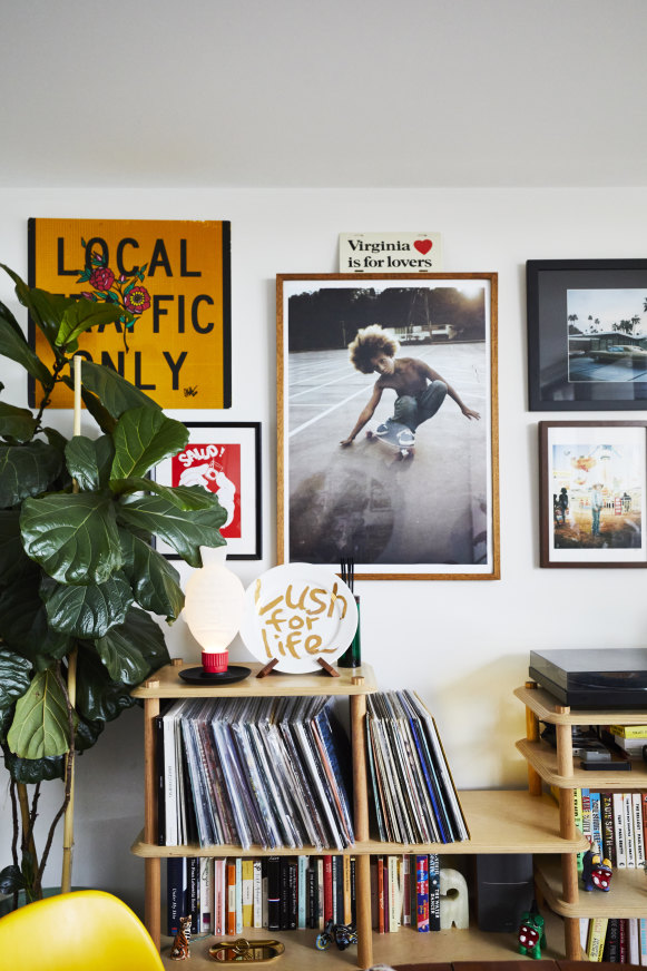 A 1970s skateboarding photo by Hugh Holland and a car photograph by Sean McDonald hang above the couple’s vinyl collection.