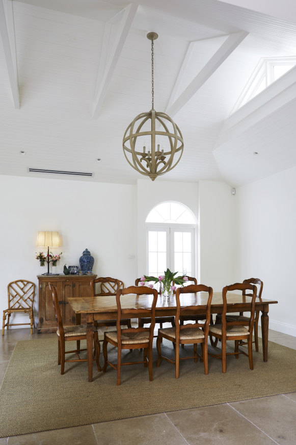 The dining room features a large orb pendant from Cromwell Furniture and an antique French fridge cabinet.  The arched double doors lead through to the conservatory.