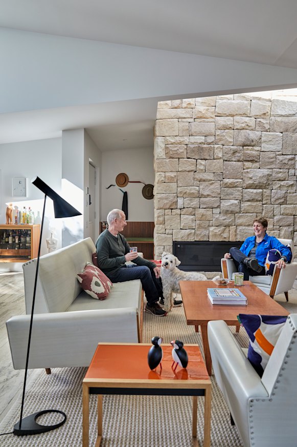 Patrick and Elizabeth Mitchell in their living room with its stone fireplace. The vintage suite is from Metro Road Trading.