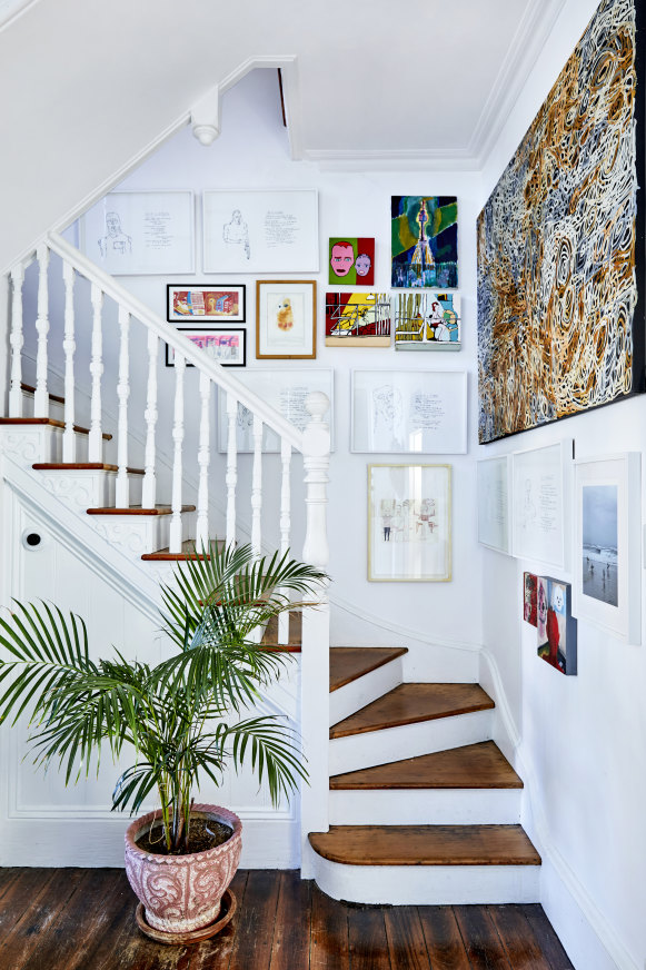 The original Victorian stairway. A large painting by Charmaine Pwerle sits among works by Cynthia, her daughter Frankie Howard-White and other artists.