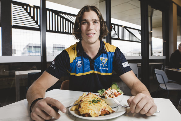 Canberra Demons player Alex Paech with his parma for a farmer at the Eastlakes club in Gungahlin.
