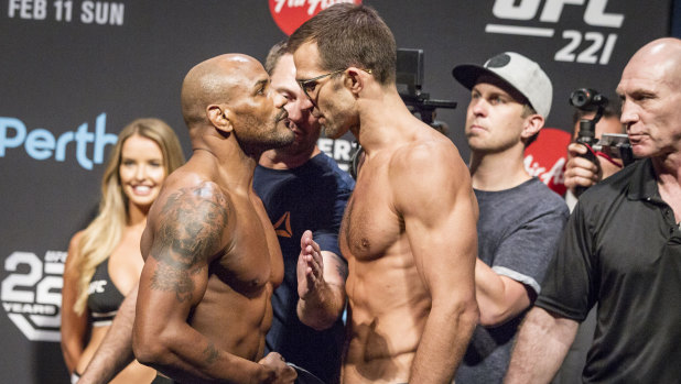 Yoel Romero (left) and Luke Rockhold are kept apart during the UFC 221 weigh-ins at Perth Arena on Saturday.