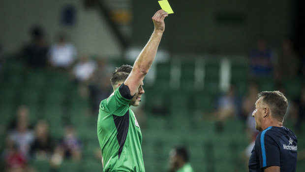 Cop that: Melbourne City coach Warren Joyce gets a yellow card during the match against Perth Glory on Saturday night.