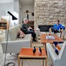 Patrick and Elizabeth Mitchell in their living room with its stone fireplace. The vintage suite is from Metro Road Trading.