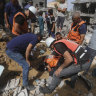 Palestinians search for survivors after an Israeli airstrike on a residential building in Nuseirat Refugee Camp.