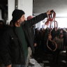 A man holds up rope at Sednaya Prison, where thousands of people were said to be detained and tortured.