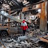 A rescue worker walks through a bombed-out workshop in Tehran on Saturday.