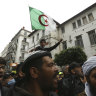 A man holds an Algerian flag while Algerians demonstrate to mark the second anniversary of the Hirak movement.