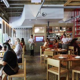 Sheets of oatmeal-toned linen sway above tables.