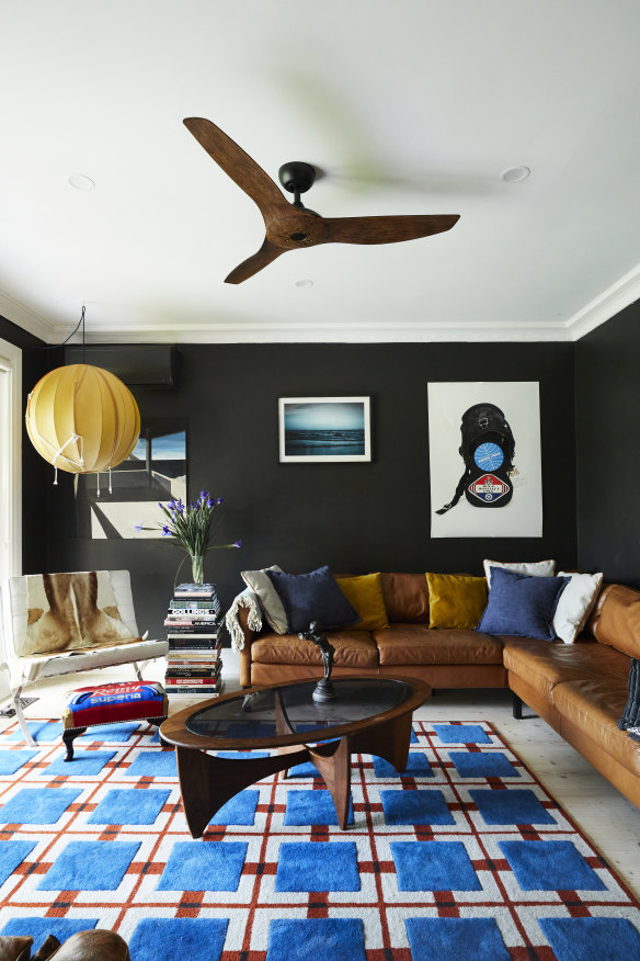 Artworks by Michael Delany, Jane Burton and Moya Delany hang above a leather sofa in the TV room.  The rug was handmade in India and the coffee table is from Leonard Joel Auctions.