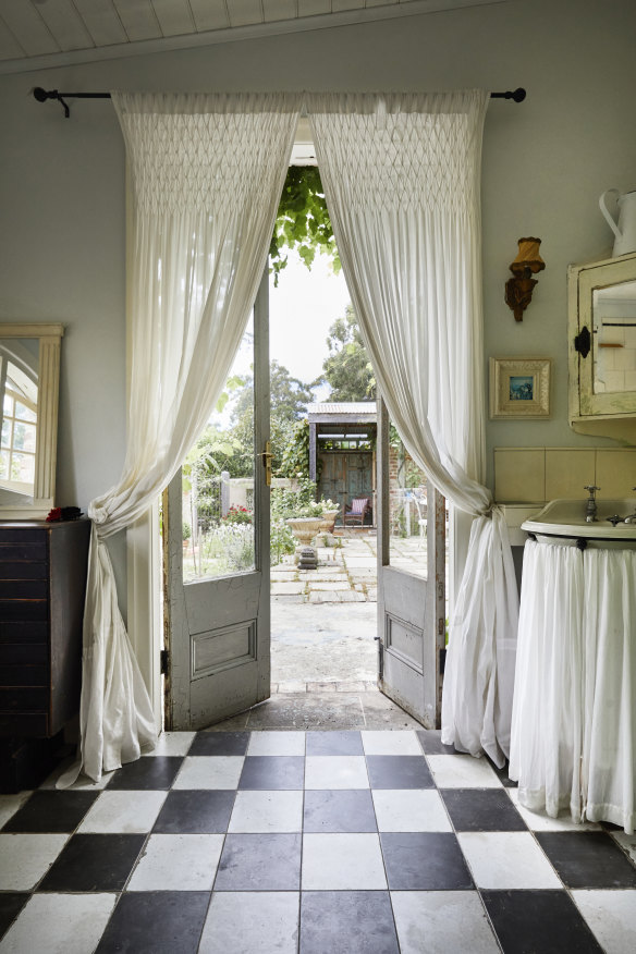 “I love the bedroom’s softer, quiet atmosphere,” says Pottage. “The lining boards came from an old biscuit factory near Melbourne.” The garden can be viewed from the bath through double French doors. The vintage corner basin was an eBay find.