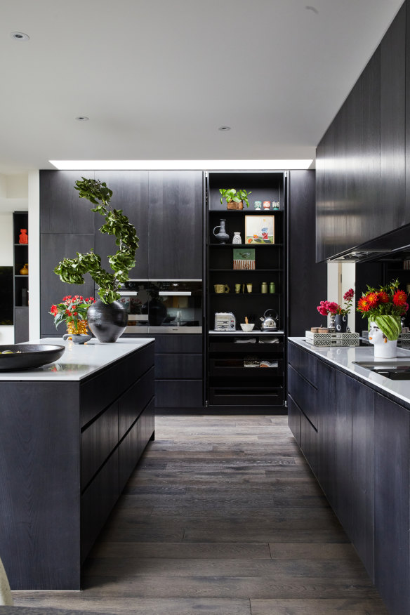 “I think it looks beautiful with the bi-fold doors open, displaying small artworks and vintage glass as well as the necessities,” says Lynda of this kitchen cabinet.