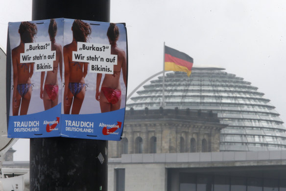 A poster of the far-right Alternative for Germany reads "Burqas? We prefer bikinis" near the Reichstag building in Berlin.