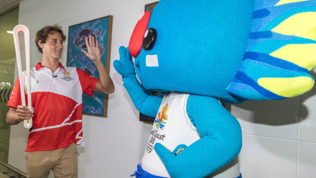 Cameron McEvoy arrives with the Queen's baton alongside Commonwealth Games mascot Borobi.