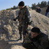 Syrian rebels observe a location identified as a mass grave for detainees killed under the rule of Bashar al-Assad in Najha, south of Damascus.