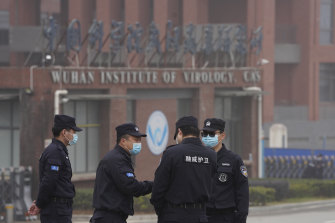 Il personale di sicurezza si riunisce vicino all'ingresso dell'Istituto di virologia di Wuhan durante una visita di un team dell'OMS a febbraio.