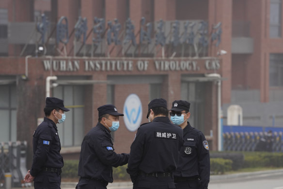 Security personnel gather near the entrance of the Wuhan Institute of Virology during a visit by the World Health Organisation team in February.
