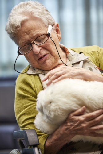 Norma interacts with Paro, the robotic baby seal.