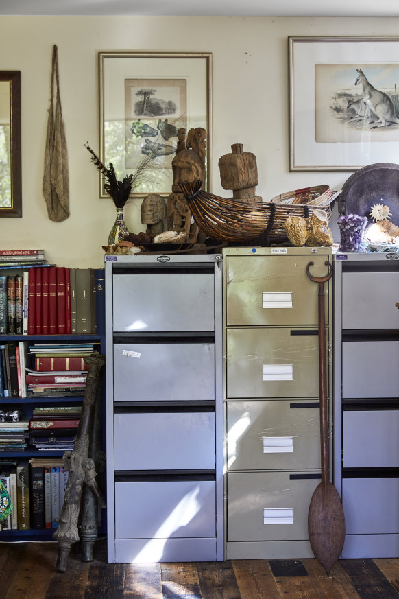 A paddle from the Solomon Islands and cannons from Indonesia rest against filing cabinets in Flannery’s office. Artefacts on top include carvings from New Guinea.