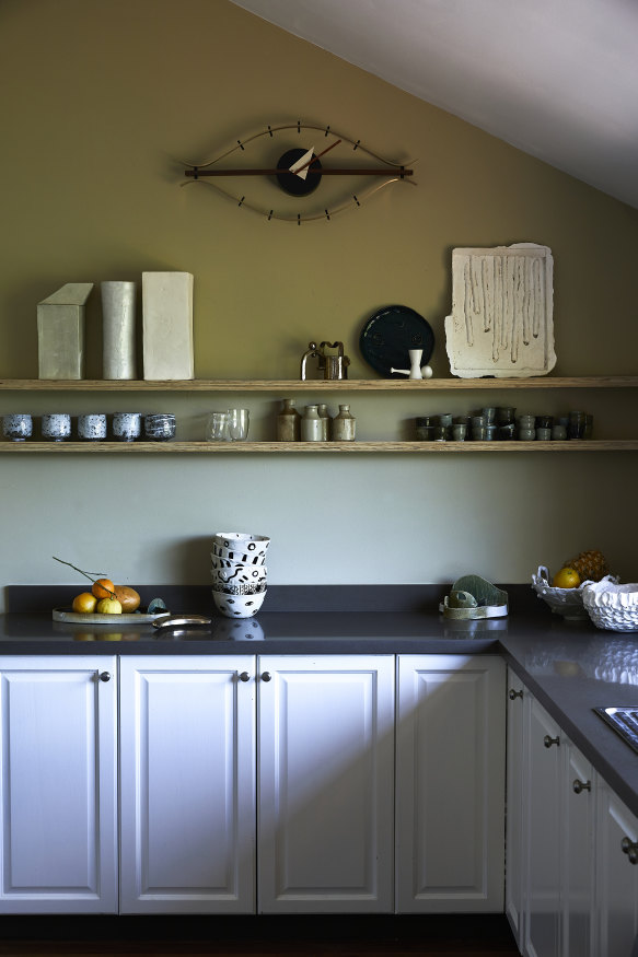 On the kitchen benchtop sit handmade noodle and fruit bowls crafted by Mestrom. Ceramic test pieces along the shelf are used as sake cups. On the wall is a George Nelson “Eye” clock.