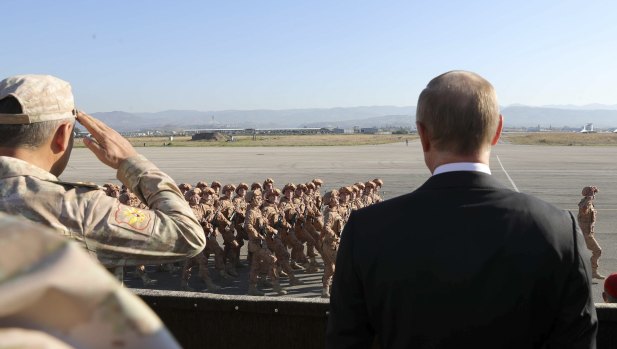 Russian President Vladimir Putin, right, watches the troops marching as he and Syrian President Bashar Assad visit the Hemeimeem air base in Syria in 2017.