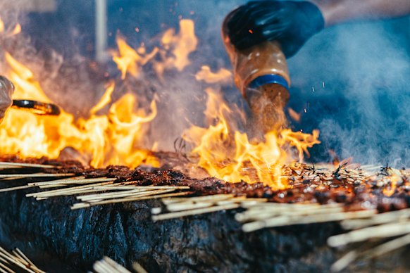 Sauce is added to grilled meats and seafoods on the streets of Singapore’s vibrant Chinatown.