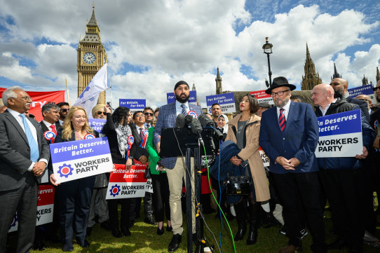 Leader of the Workers Party of Britain George Galloway (right) looks on as former England cricketer Monty Panesar (centre) addresses fellow party candidates in Parliament Square.