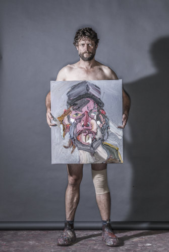 Quilty holds the painting Self Portrait after Injury No.4, 2018. 