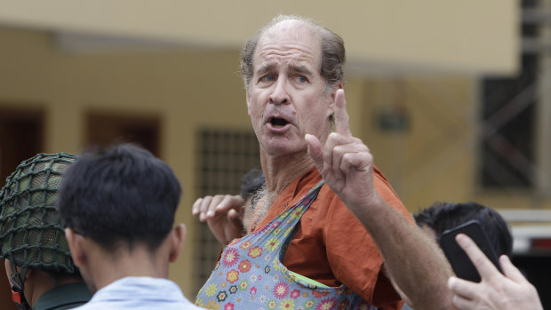 Australian filmmaker James Ricketson gestures as he is escorted by prison guards at the Cambodian Supreme Court in Phnom Penh, Cambodia, on January 17.