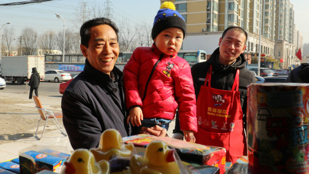 William Qu, 4, and his grandpa at a fireworks and crackers stand in Chaoyang District of Beijing.