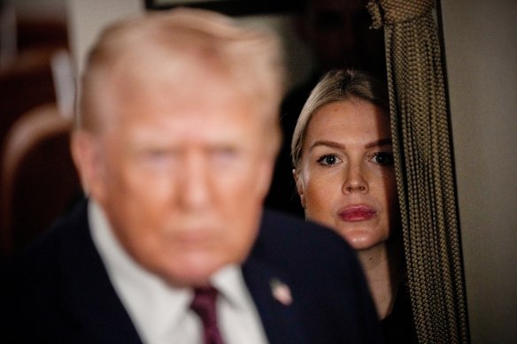 White House press secretary Karoline Leavitt watches as US President Donald Trump speak to reporters while in flight...