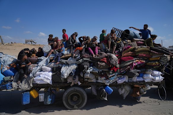 Displaced Palestinians fleeing northern Gaza carry their belongings along the coastal road toward southern Gaza.