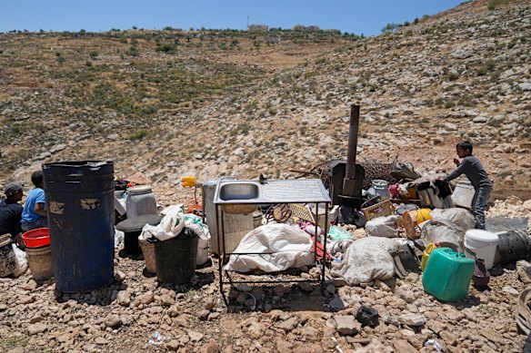 Palestinian bedouin children sit near their home belongings at the site of their demolished tents and shacks on the outskirts of the West Bank town of Duma. Israeli forces demolished on Thursday a cluster of tents and shacks and confiscated a vehicle, that belong to two Palestinian brothers Mohammed and Salama Zawahra, Mohammed Zawahra said.