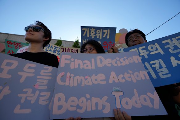 People hold signs during a press conference outside of the Constitutional Court, in Seoul, South Korea