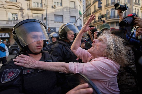 Delia Donn, 78, gestures to a riot policeman near Congress during weekly protests demanding better pensions for retirees, in Buenos Aires, Argentina.