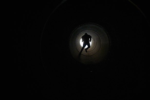 A boy runs inside cement pipe turned into a bomb shelter as air raid sirens warn of incoming Iranian missile strike in Michmoret, Israel.