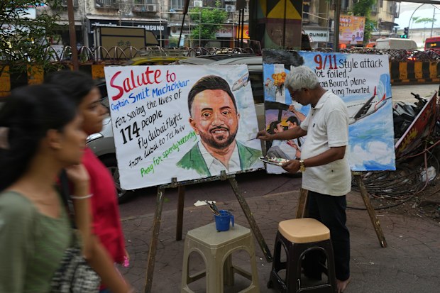 A teacher from Gurukul School of Art paints a portrait honoring Smit Machchhar,, an Indian pilot with FlyDubai, in Mumbai, India, Thursday, Oct. 1, 2026.