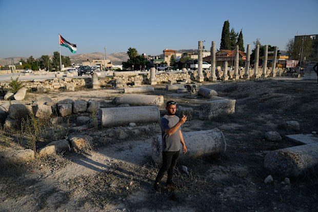 A Palestinian visitor takes a photo at the Roman historical site in the West Bank town of Sebastia Thursday, Nov. 20, 2025. 