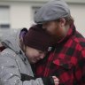 People gather at a makeshift memorial near the scene of a shooting on the outskirts of Orebro, Sweden.