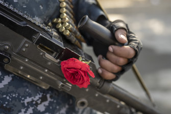 A Taliban fighter with a rose on his machine gun secures an area in Kabul last weekend.