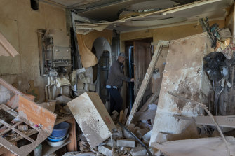 Alexander, 67, checks the flat of his neighbour destroyed by shelling in Kutuzivka, near Kharkiv, eastern Ukraine.
