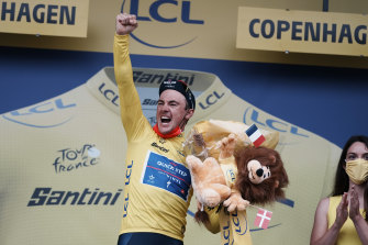 Le vainqueur d'étape belge Yves Lampaert, portant le maillot jaune de leader absolu, célèbre sur le podium.