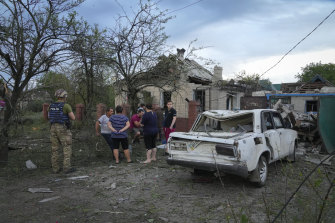 Sakinler Çarşamba günü Ukrayna'nın Donetsk bölgesi Pokrovsk'ta Rus roket saldırısında hasar gören evlerin yakınında toplanıyor.