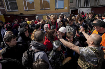 Residents wait for aid in a Chernihiv schoolyard.