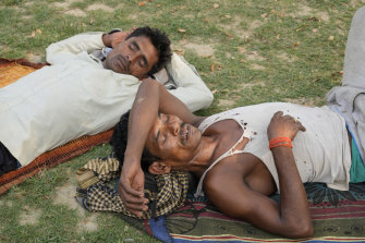 People sleep in the shade of a tree on a hot summer afternoon in Lucknow in the central Indian state of Uttar Pradesh. 