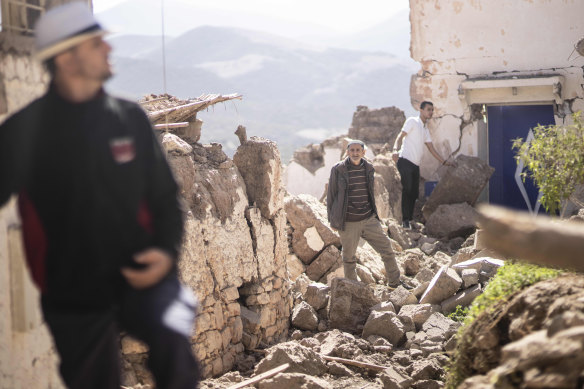 People inspect their damaged homes after the earthquake. 