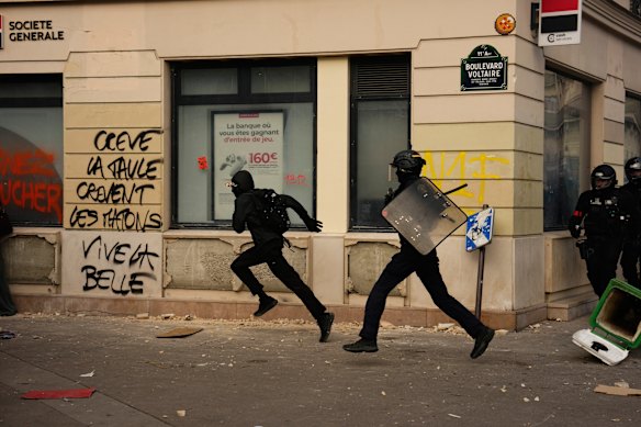 A police officer chases a protester in Paris.