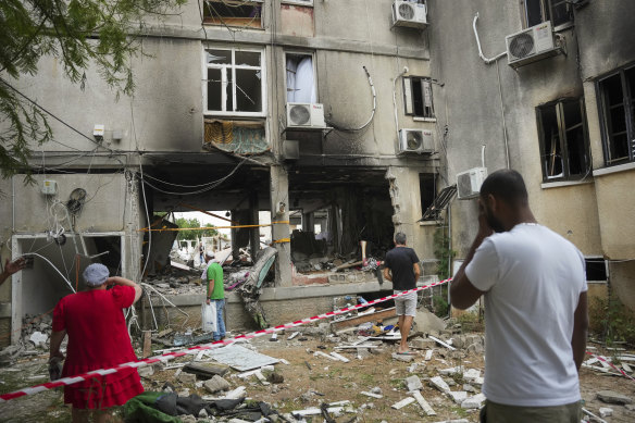Residents in Ashkelon, Israel inspect a damaged building on Monday after it was hit by a rocket fired from the Gaza Strip.