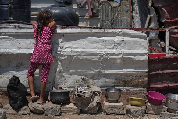 A Palestinian girl waits at a community kitchen before donated food is distributed in Gaza City on Friday.